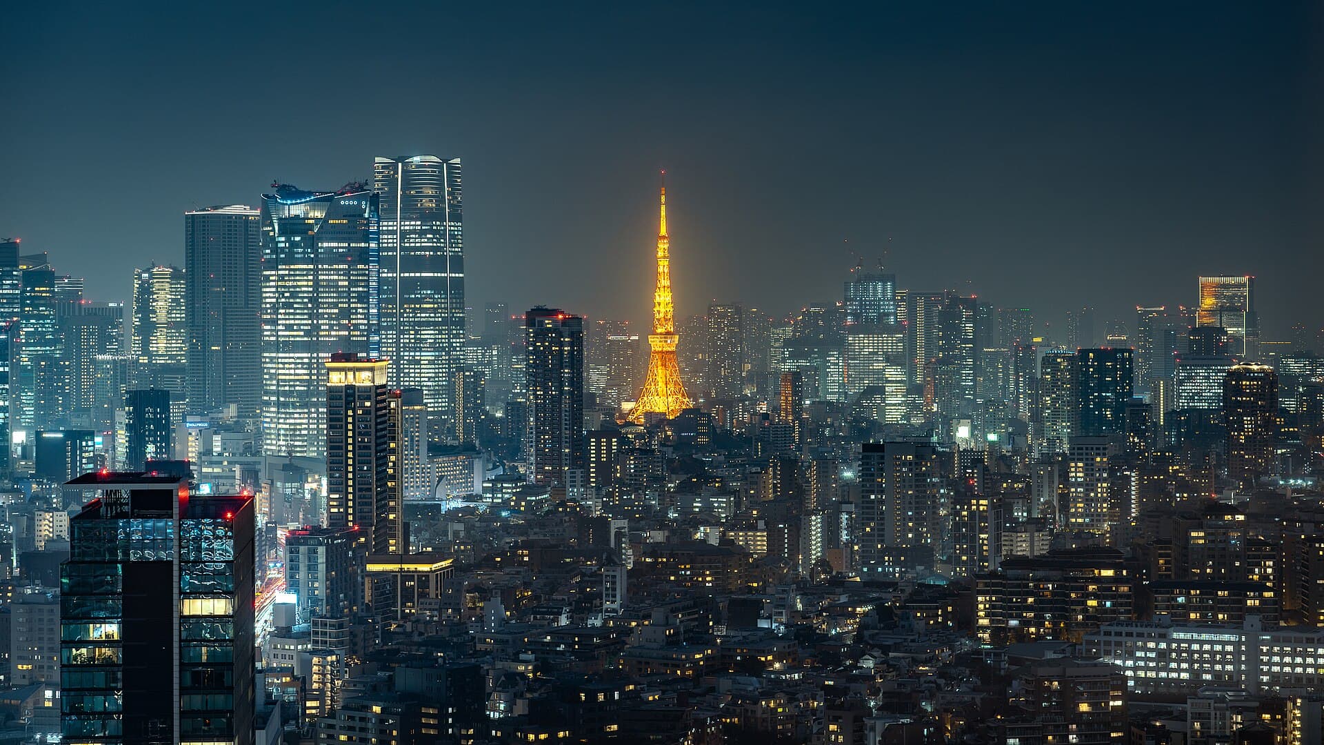 Tokyo Tower illuminated above the Minato City skyline at night